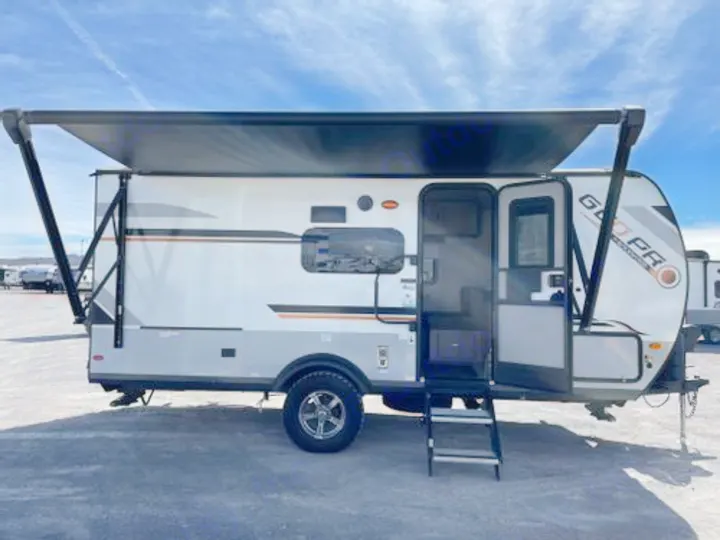This white and gray travel trailer rv rental, with its extended black awning and open entry steps, is ready for your next getaway.. Forest River Rockwood Geo Pro 2022