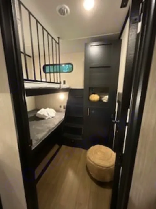 Cozy RV rental bunkhouse interior: compact sleeping area with comfortable bunk beds, perfect for guests.. Forest River Wildcat 2022