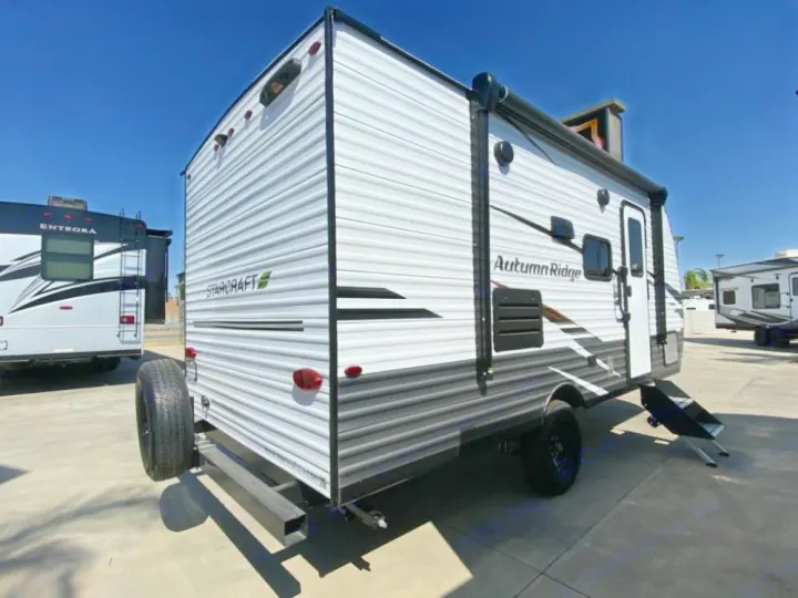 This white Starcraft Autumn Ridge travel trailer, with a rear spare tire and side awning, is available for rv rental.. Starcraft Autumn Ridge 2023