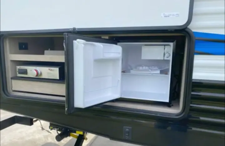 This RV rental features a convenient outdoor kitchen: a mini-fridge on the right and a pull-out griddle on the left.. Heartland RVs Prowler 2022