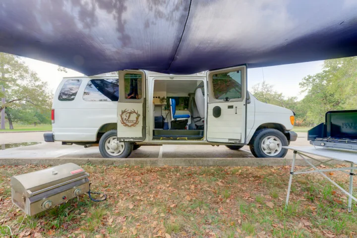 This rv rental camper van is set up for a comfortable outdoor experience with an awning, portable grill, and camp stove.. Ford Ford E350 2007