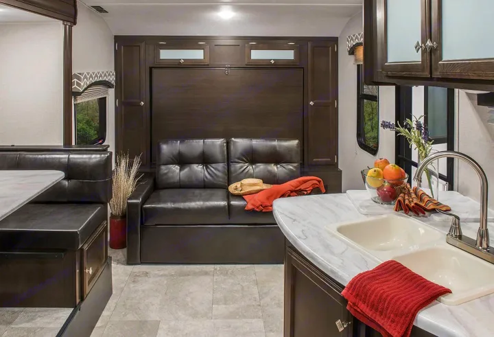 Functional RV rental interior with a versatile sofa, dinette, and full kitchen setup. Ready for travel adventures.. Sonic Sonic Trailer 2019