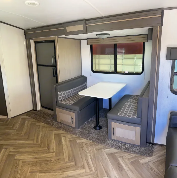 RV rental: Modern dinette with gray & patterned seats, white table, wood-look flooring, and a refrigerator visible. Perfect for travel.. Cruiser Rv Corp Shadow Cruiser 259BHS 2021
