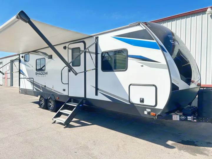 Bright, modern white and black Shadow Cruiser travel trailer RV with extended awning and deployed steps, ideal for an rv rental.. Cruiser Rv Corp Shadow Cruiser 259BHS 2021