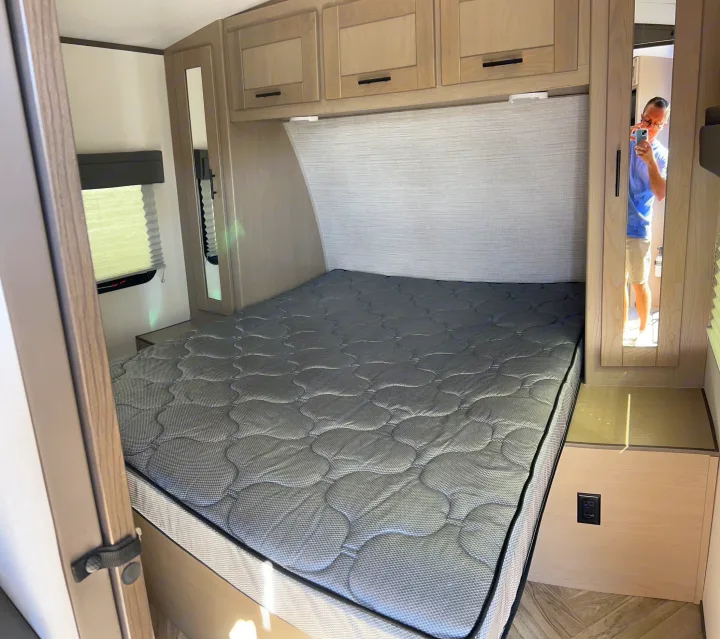 Inside a cozy RV rental bedroom: a comfortable bed with a patterned mattress, overhead cabinets, and essential amenities.. Cruiser Rv Corp Shadow Cruiser 259BHS 2021