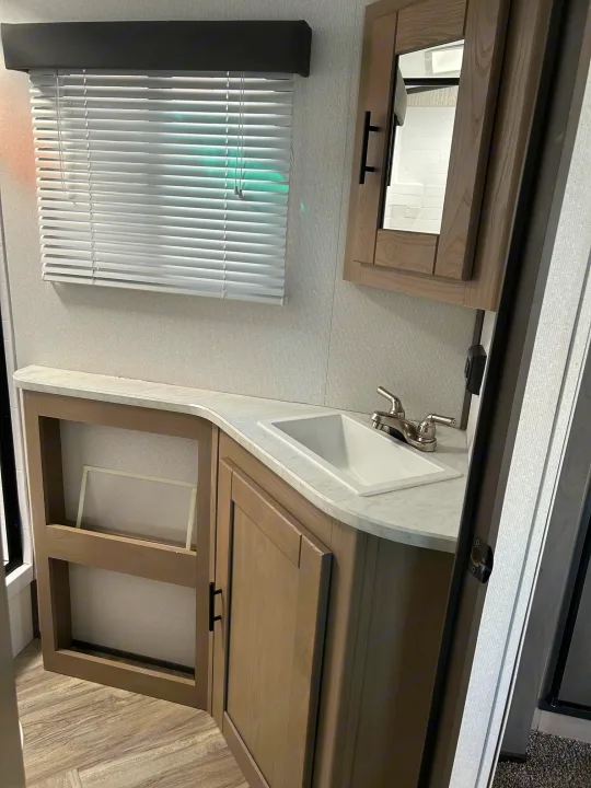 This clean RV rental bathroom features a modern vanity with a sink, faucet, mirror cabinet, and window blinds.. Cruiser Rv Corp Shadow Cruiser 259BHS 2021