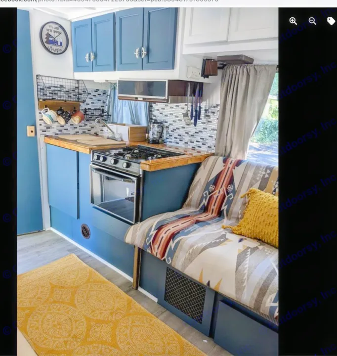 Charming RV rental interior: bright blue kitchen, wood counters, full oven & cozy patterned bench seat for travel.. Chevrolet Open Road 1982