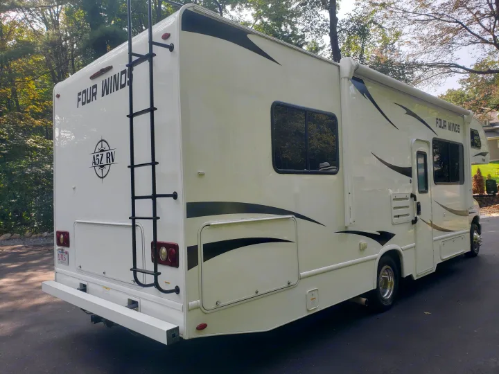 White Four Winds Class C RV. Perfect for your next rv rental, featuring a rear ladder & side awning.. Thor Four Winds 2021