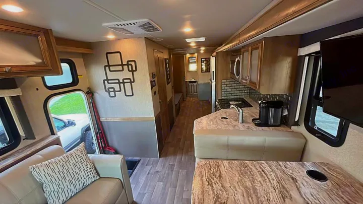 Light and modern RV rental interior featuring a full kitchen, living space, and wood flooring.. Flair-Fleetwood Flair-Fleetwood Motorhome 2020
