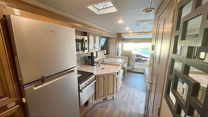 Bright RV rental interior featuring a full kitchen with stainless appliances, dinette, and front cockpit view.. Flair-Fleetwood Flair-Fleetwood Motorhome 2020