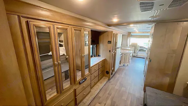 Spacious RV rental interior, showing bedroom reflection in mirrored cabinets, kitchen, and ample storage areas.. Flair-Fleetwood Flair-Fleetwood Motorhome 2020