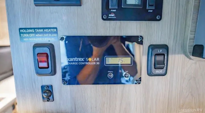 RV rental control panel with a solar charge controller (15V), holding tank heater switch, and LP valve control.. Winnebago Solis 2023