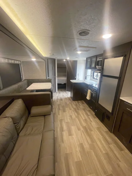 Spacious RV rental interior with modern kitchen, living area, dinette, and private bedroom. Your perfect travel home!. Forest River Cruise Lite 2019