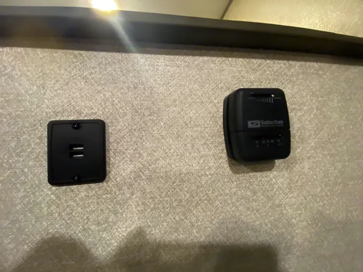 RV rental interior featuring a Suburban thermostat for climate control and a USB charger on a textured wall.. Forest River Salem FSX 2020