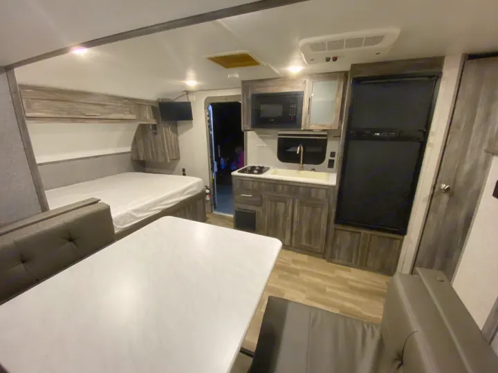 RV rental interior showcasing a cozy living space with bed, kitchen, and dining area. Ready for your travel adventures!. Forest River Salem FSX 2020