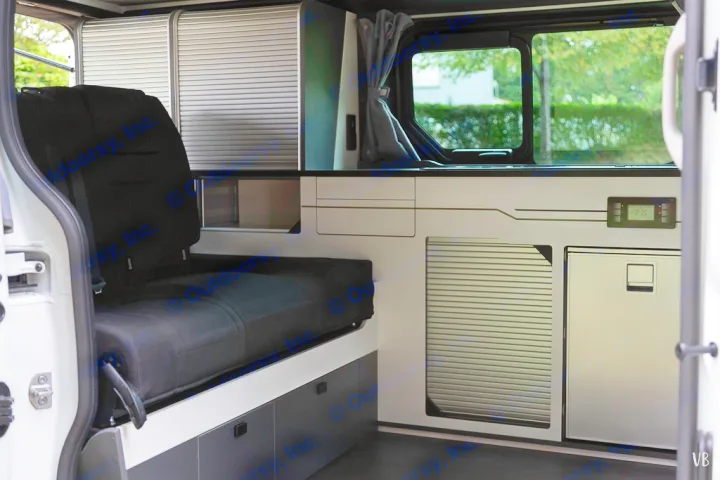 View inside an RV rental, featuring a convertible seat/bed, slatted storage, built-in fridge, and digital control panel.. HANROAD TREK 4 2024