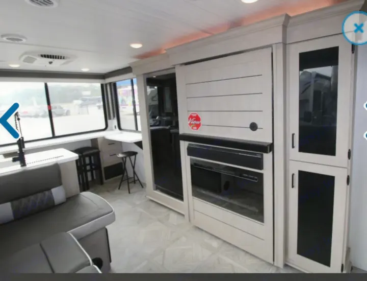 Spacious, modern RV rental interior featuring a living area, dining counter, and built-in entertainment.. Forest River Wildwood XLite View 2024
