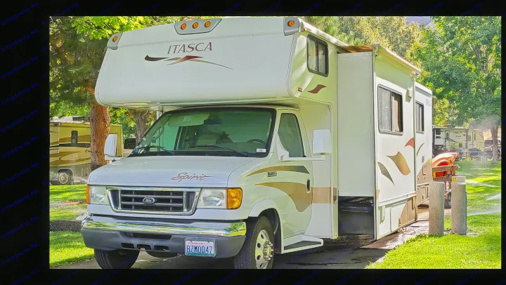 White Itasca Spirit RV rental parked at a sunny campground with trees, green grass, and sprinklers, ideal for travel.. Itasca Spirit 2007