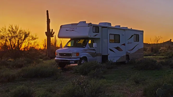 Enjoy a stunning desert sunset from your RV rental. An Itasca motorhome is perfectly positioned among saguaro cacti.. Itasca Spirit 2007