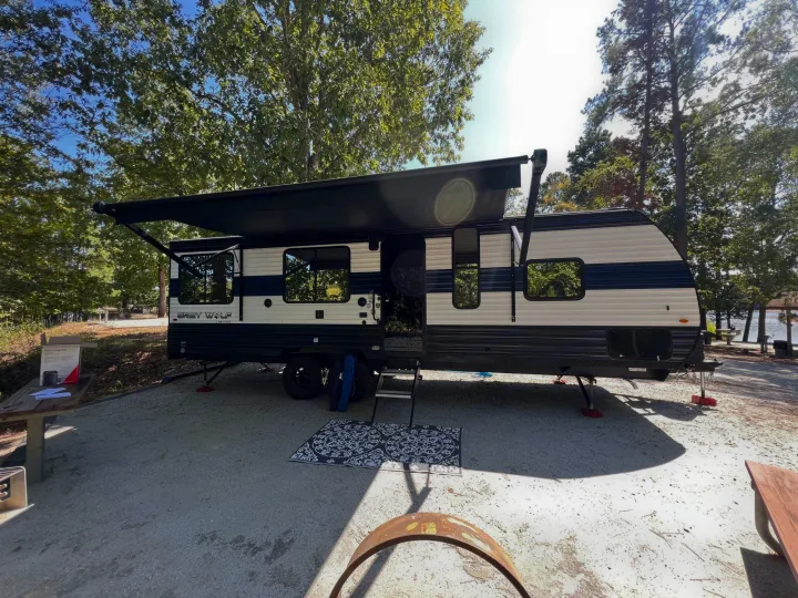 Lakeside rv rental camping with a Grey Wolf travel trailer. Awning extended for a relaxing, sunny campsite.. Forest River Cherokee Grey Wolf 2024