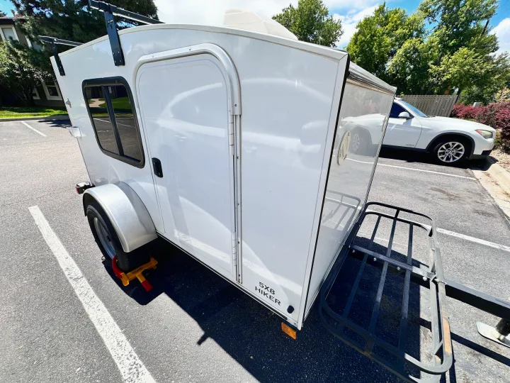 White 5x8 Hiker compact travel trailer, an ideal RV rental with roof and rear cargo racks for adventures.. Hiker Deluxe 2018