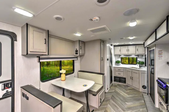 Bright RV rental interior showcasing a modern kitchen, cozy dinette, and large windows with outdoor views.. Heartland RVs Mallard 2023