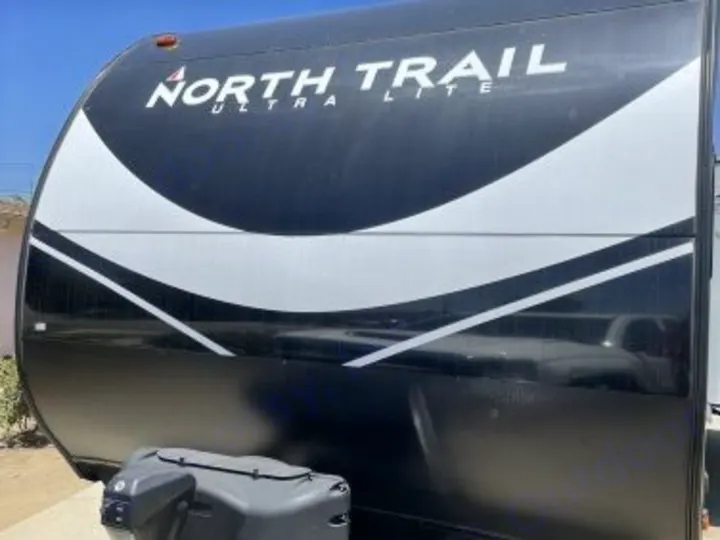 Front of a black North Trail Ultra Lite travel trailer. Consider this RV rental for your next travel adventure.. Heartland RVs North Trail 2021