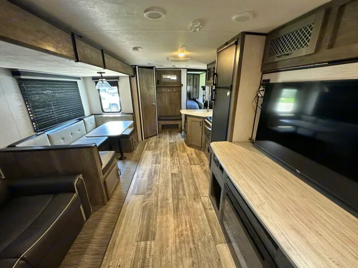 Spacious RV rental interior featuring a modern living area, kitchen, and dining booth. Perfect for family adventures.. Heartland RVs North Trail 2021