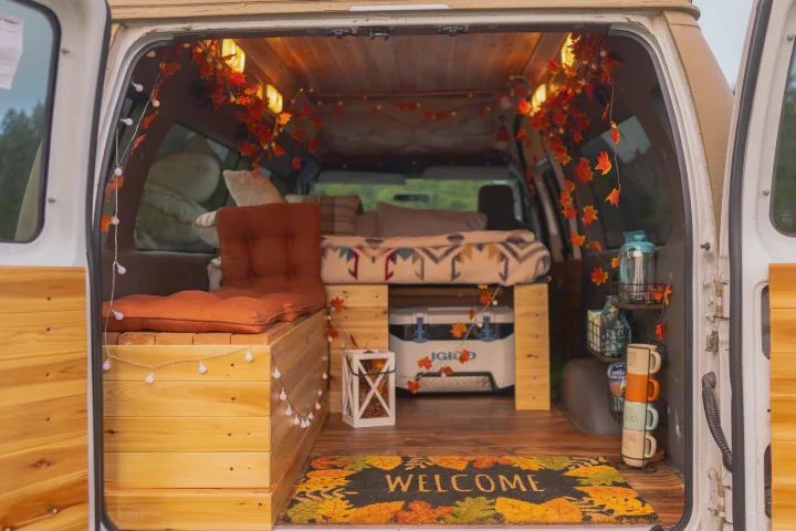 This RV rental boasts a cozy, autumn-themed interior with a bed, seating, and charming fall decorations like leaf garlands.. Ford Ford E350 2006