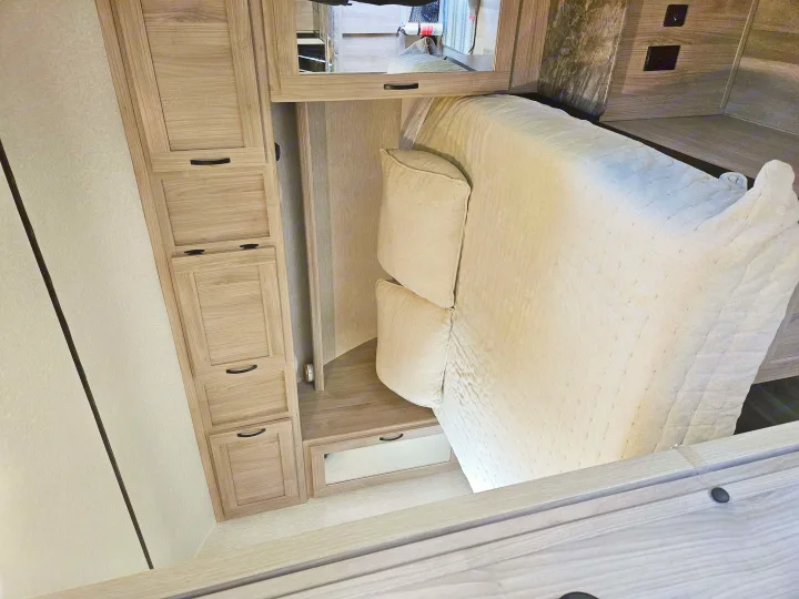 Inside an RV rental: Modern interior features a comfortable bed, light wood cabinetry, and integrated storage options.. Coachmen Northern Spirit 2454BH 2022