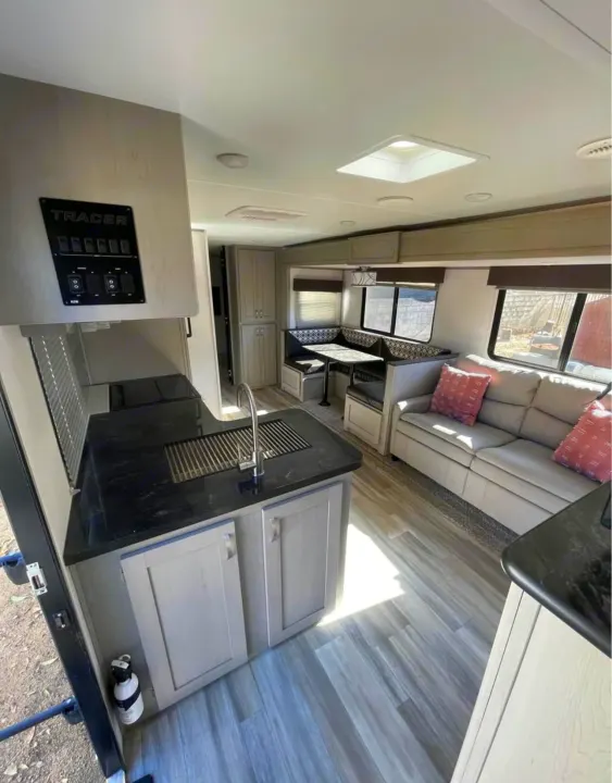 Explore this Tracer RV rental's spacious interior: kitchen, dinette, and sofa area. Your ideal travel trailer escape.. Forest River Tracer 2021