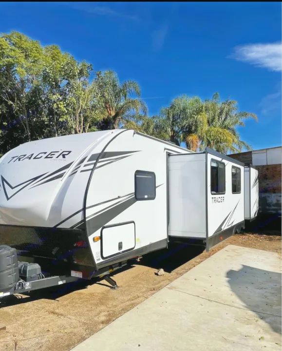 Stunning white Tracer travel trailer with slide-outs extended, perfect for rv rental adventures under a clear blue sky.. Forest River Tracer 2021
