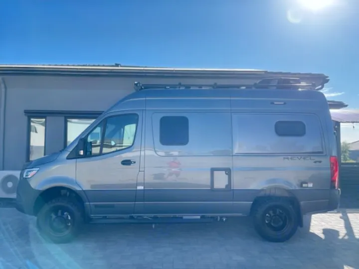 Gray Winnebago Revel 4x4 Sprinter camper van for rv rental, parked on a sunny day. Ideal for outdoor adventures.. Winnebago Revel 2024
