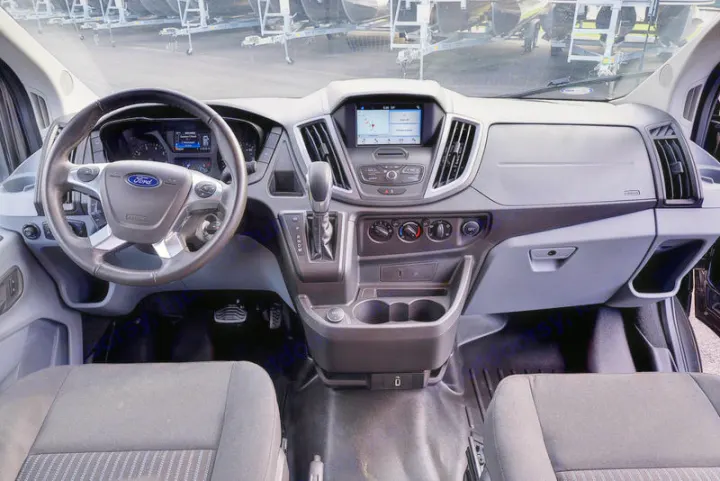 Ford Transit van interior for RV rental: spacious dashboard, steering wheel, and navigation screen for easy travel.. Coachmen CrossFit 22c 2019