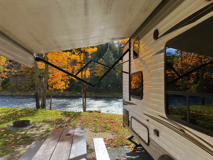 Riverside rv rental view: RV with awning, stunning fall foliage by the river, picnic table and fire pit.. Jayco Jay Flight SLX 2017