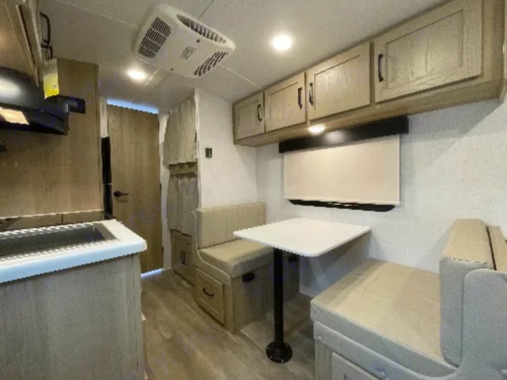 Compact RV rental interior with a modern kitchen, comfortable dinette seating, and AC, perfect for travel.. Forest River Rockwood Geo Pro 2022