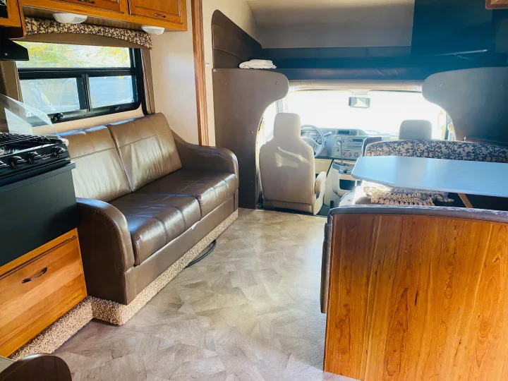Inside a comfortable rv rental: a living area with sofa, kitchen, dinette, and cockpit. Perfect for your next adventure.. Jayco Redhawk 2016