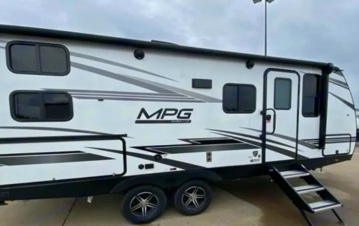Modern white travel trailer, ideal for rv rental, featuring sleek black/gray graphics, tinted windows, and deployable steps.. Cruiser RV MPG 2023
