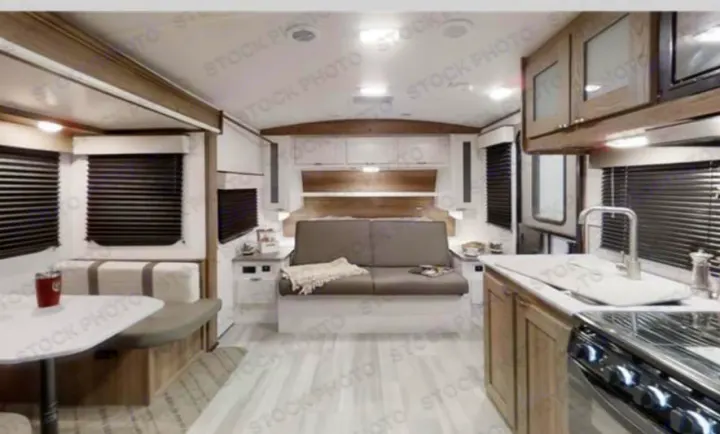 Explore this modern RV rental interior: a bright living space with dinette, sofa, and full kitchen.. Cruiser RV MPG 2023