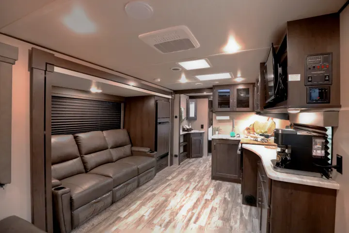 Modern RV rental interior with a spacious living area, comfortable recliners, and a well-equipped kitchen.. Grand Design Transcend Xplor 2022