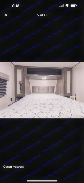 RV rental bedroom showcasing a queen bed with patterned comforter, upholstered headboard, and built-in cabinetry.. Grand Design Transcend Xplor 2021