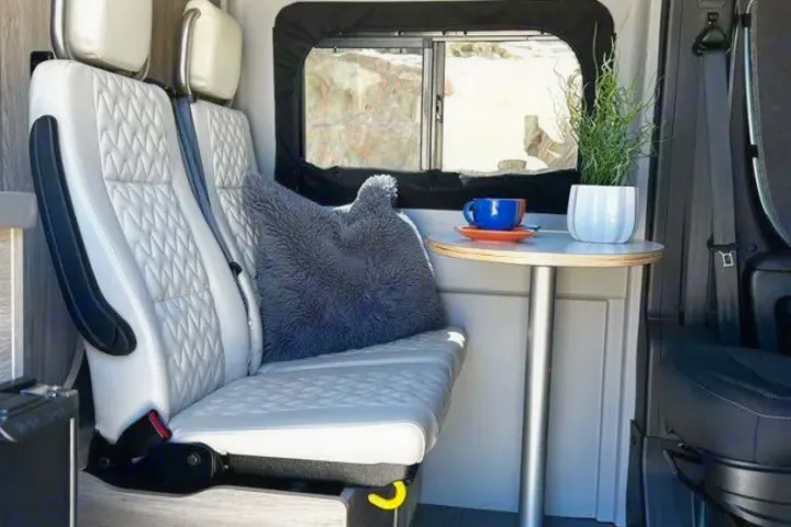 Cozy RV rental interior with dinette seating, a small table, and a window view. Perfect for travel comfort.. Winnebago SOLIS 59 PX 2023