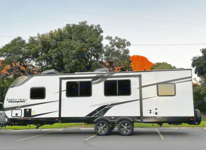 This sleek RV rental, a North Trail trailer, is ready for scenic journeys against a vibrant red mountain backdrop.. Heartland RVs North Trail 2023