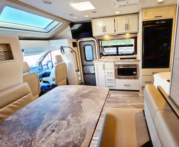 Spacious RV rental interior with a modern kitchen, comfortable dining area, front cab, and ample storage for your next adventure.. Thor Compass 2022