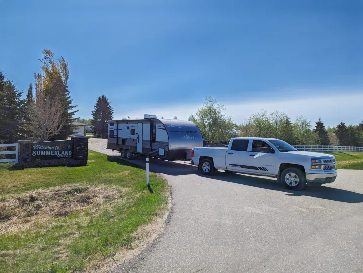 RV rental ready for adventure: White truck tows a Grey Wolf travel trailer into Summerland RV Park under blue skies.. Forest River Cherokee Grey Wolf 2014