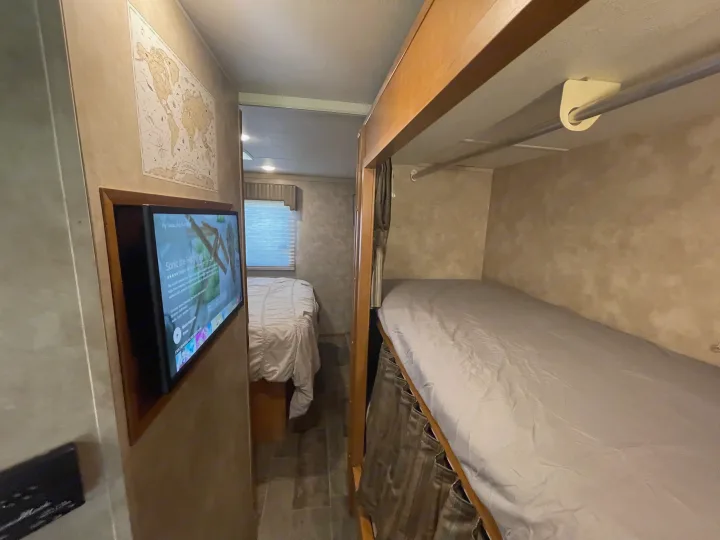 Cozy RV rental interior featuring a bunk bed and a separate bedroom with a double bed, ready for travel.. Winnebago Minnie Winnie 2019