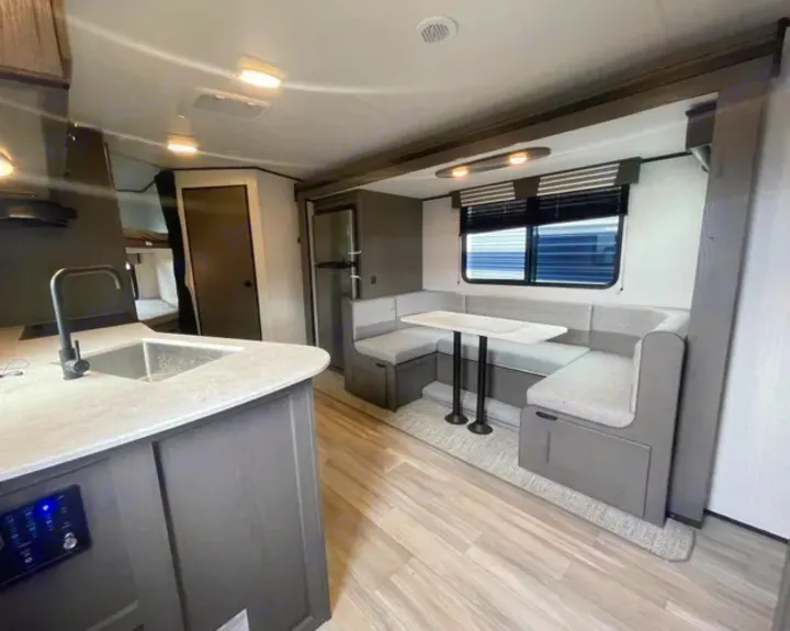 Spacious RV rental interior featuring kitchen, U-shaped dinette, and bunk beds. Perfect for family trips.. Cruiser RV MPG Ultra Lite 2022