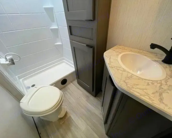 Step inside this RV rental's compact bathroom, showcasing a white shower, toilet, and sink vanity.. Cruiser RV MPG Ultra Lite 2022