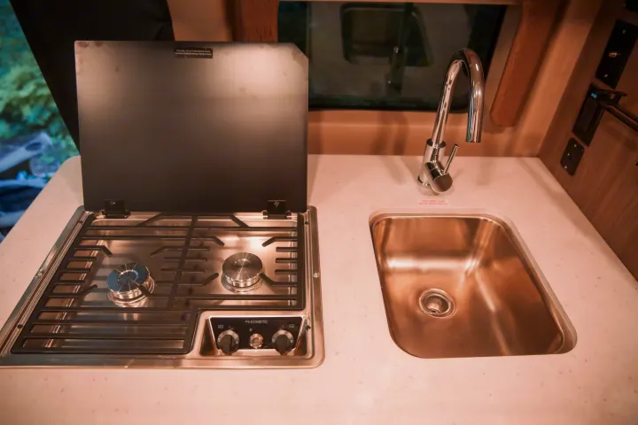 This RV rental features a compact kitchen with a Dometic 2-burner stove and stainless steel sink.. Thor Rize 2022