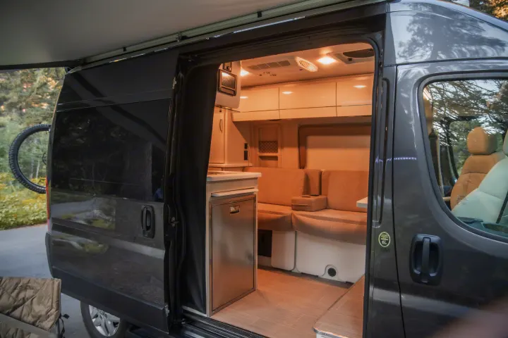 Explore this modern RV rental's inviting interior. It features a kitchen, comfortable seating, and an extended awning, ready for adventure.. Thor Rize 2022